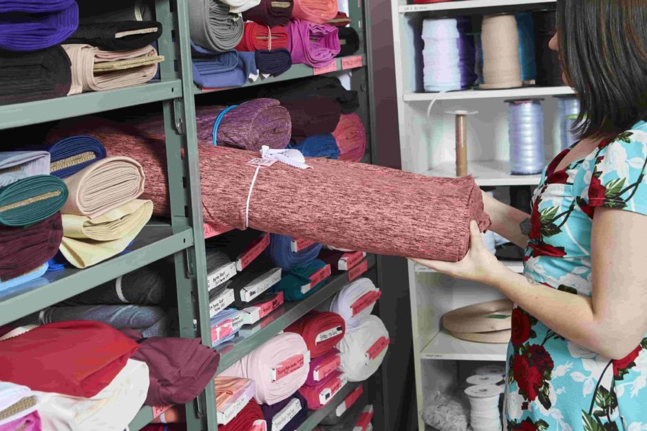 woman pulling out textile from a shelf