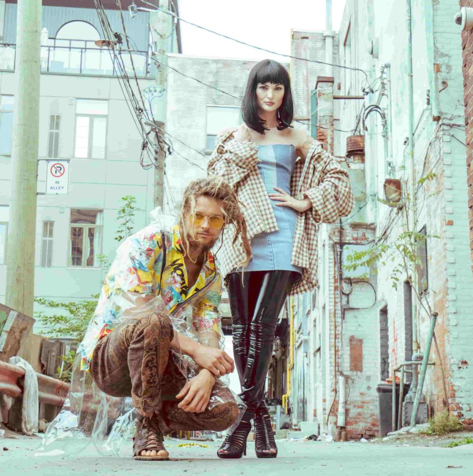 male fashion model and female fashion model standing in an alleyway