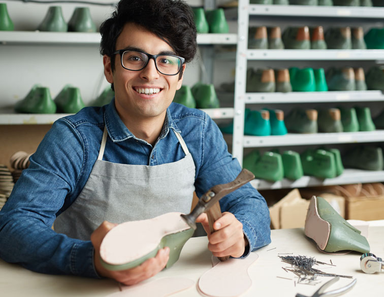 Young business owner making handmade shoes