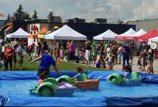 Kids playing in a pool at an outdoor festival.