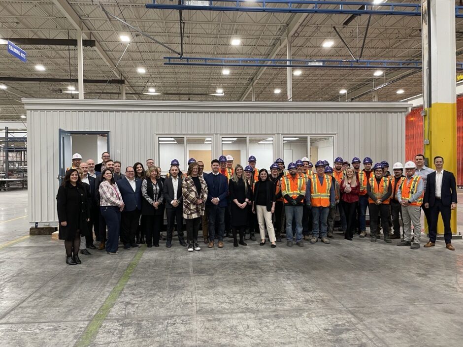 Group photo in front of a modular home in production at Fero International
