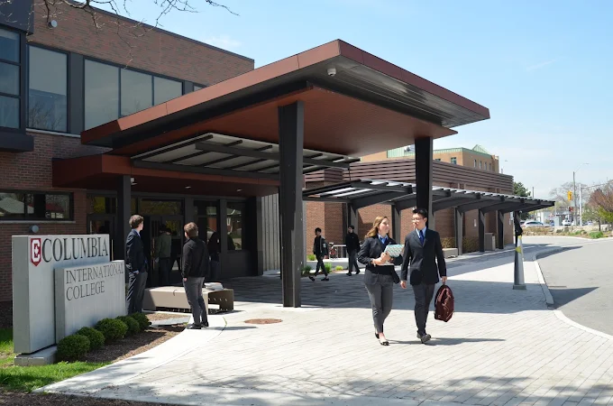 People walking outside the entrance of Columbia International College on a sunny day.