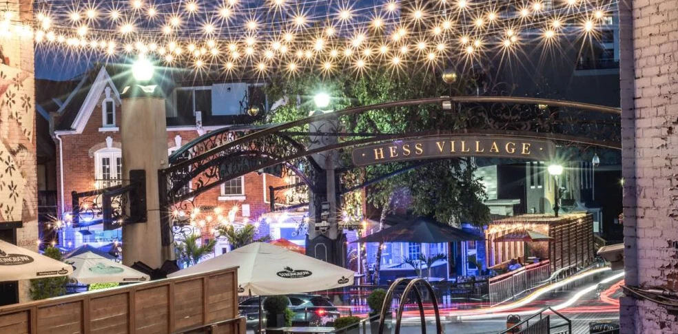 Hess Village in Hamilton, Ontario, with lights streaming across the buildings and street lights in celebration of the holiday season
