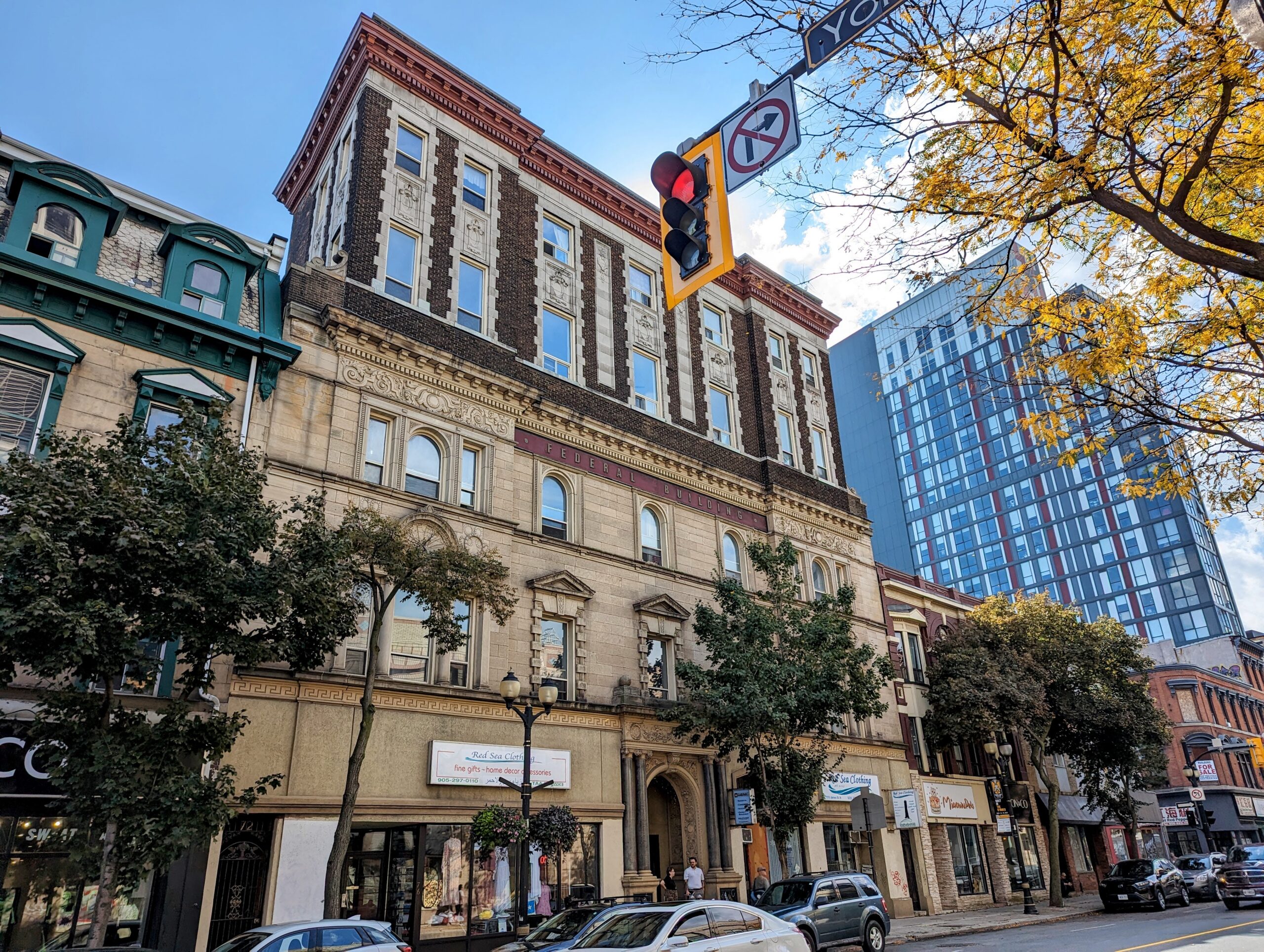 An historical Canadian federal building and a row of commercial businesses below on James Street in Hamilton, Ontario